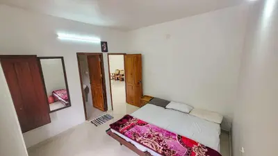 a small room with a bed and a mirror at Home stay in Kanthalloor