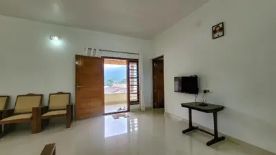 a living room with a television and a table and chairs at Home stay in Kanthalloor