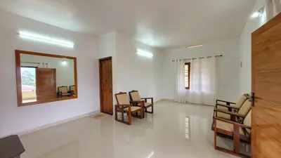 a living room with chairs and a mirror on the wall at Home stay in Kanthalloor