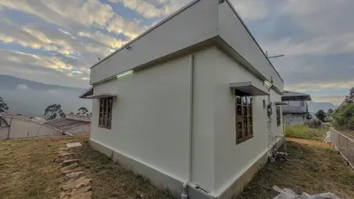 a white building with windows on the side of it at Home stay in Kanthalloor
