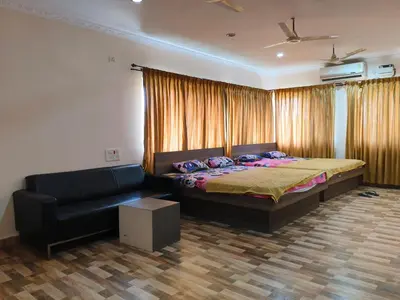 a bedroom with a bed and a couch at Konar Mandabam in Palani