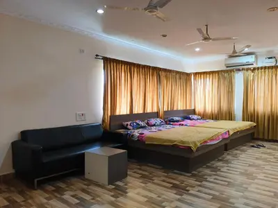 a bedroom with a bed and a couch at Konar Mandabam in Palani