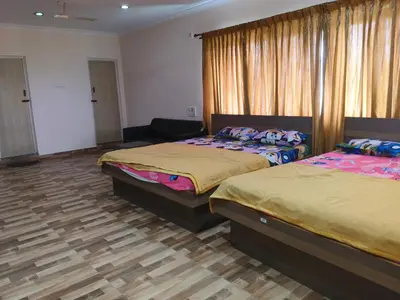 a bedroom with two beds and a couch at Konar Mandabam in Palani