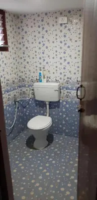 a bathroom with a toilet in a blue and white wall at Hotel Rams in Coimbatore