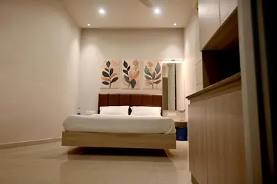 a bedroom with a bed and a painting on the wall at K.K RESIDENCY in Palakkad