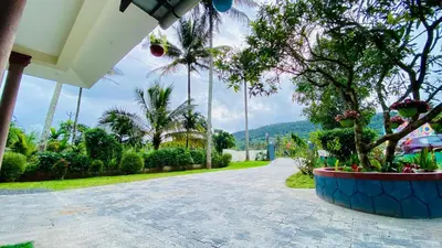 a walkway with trees and plants in a house at Captain's Cove Home Stay in Sultan Bathery