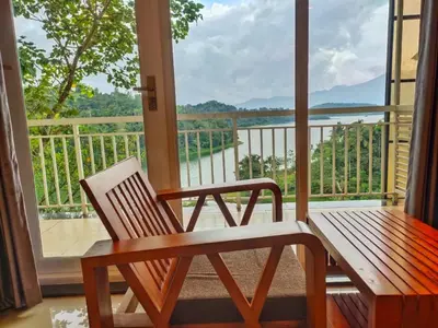 a porch with a bench and a view of the water at Mizzle Resort in Padinjarathara