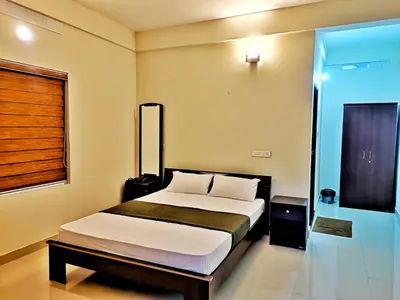 a bedroom with a bed and a window at Mizzle Resort in Padinjarathara