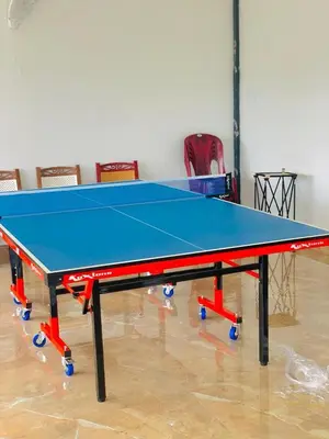 a ping pong table in a room with chairs at Mizzle Resort in Padinjarathara
