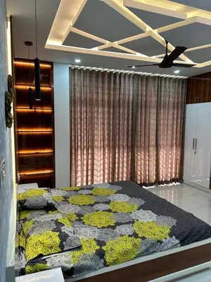 a bedroom with a large bed with yellow flowers on it at Thottan house in Trichūr