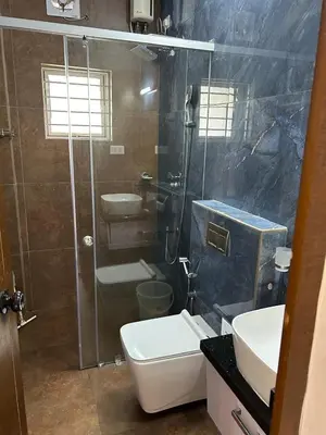 a bathroom with a shower and a toilet and a sink at Thottan house in Trichūr