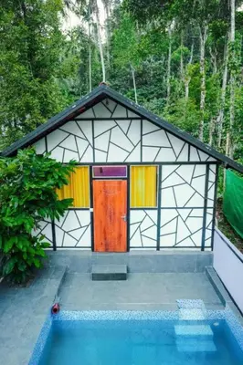 a small house with a pool in front of it at Josh Holidays Wayanad in Vaduvanchal
