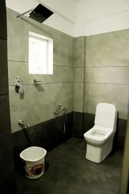 a bathroom with a toilet and a window at Jayalakshmi Residency in Vaduvanchal