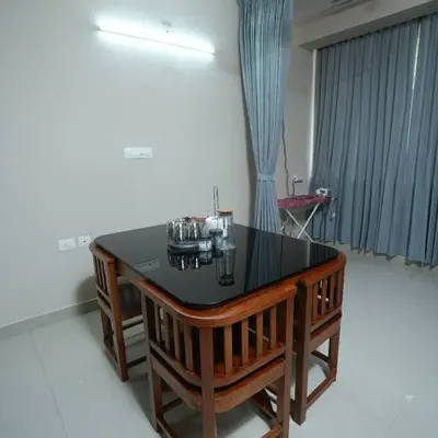 a dining room with a black table and chairs at A4, Melam, Hima Havens- 200 m from Guruvayoor Temple in Guruvāyūr