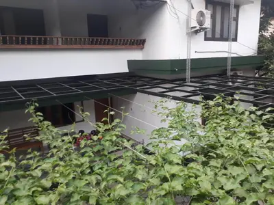 a house with a green roof and a plant at NIT Calicut Apartment in Tāzhekkod