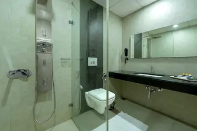 a bathroom with a shower and a toilet and a sink at Hyson heritage calicut in Kozhikode