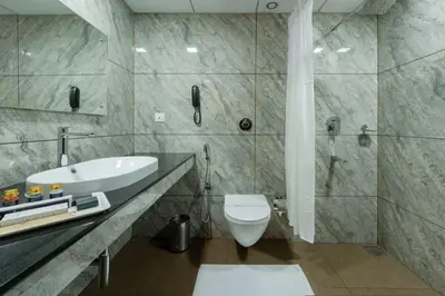 a bathroom with a white toilet and a sink at Hyson heritage calicut in Kozhikode