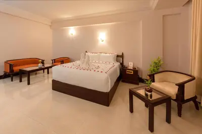 a hotel room with a bed and a chair at Hyson heritage calicut in Kozhikode