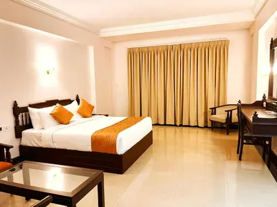 a hotel room with a bed and a desk at Hyson heritage calicut in Kozhikode