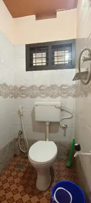 a bathroom with a white toilet and a window at Nirmalyam Homestay in Kuttippuram