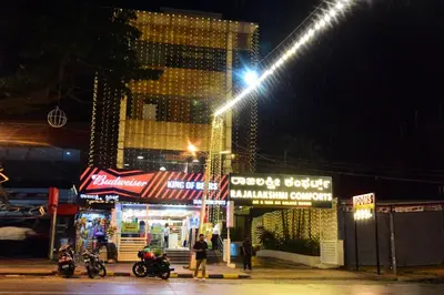 a building at night with motorcycles parked in front at Rajalakshmi Comforts Mysuru in Mysore