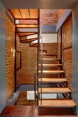 a staircase in a brick building with wooden steps at Vettaths in Kozhikode