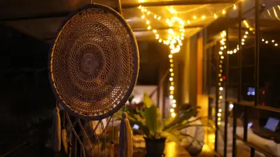 a mirror hanging on a fence with christmas lights at Vettaths in Kozhikode
