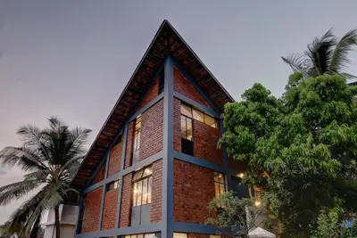 a brick building with trees in front of it at Vettaths in Kozhikode