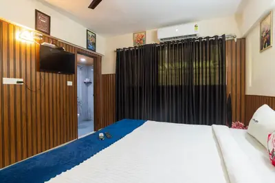 a bedroom with a bed and a flat screen tv at Mayflower Airport Launge cochin international airport in Nedumbassery