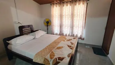 a bedroom with a large bed with a window at Flintstone Home in Kushālnagar