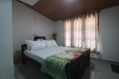 a bedroom with a bed and a window at Flintstone Home in Kushālnagar