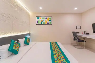 a hotel room with a bed and a desk and a chair at Treebo Sanmaya Retreat, 15 Mins From Mysore Palace in Mysore