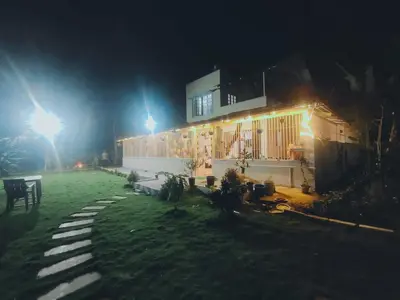 a building with lights on the side of it at night at Suggi Farm House in Halgūr