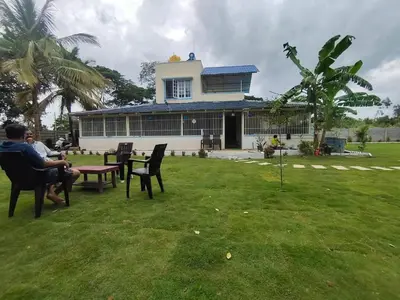 two people sitting in chairs in the yard of a house at Suggi Farm House in Halgūr
