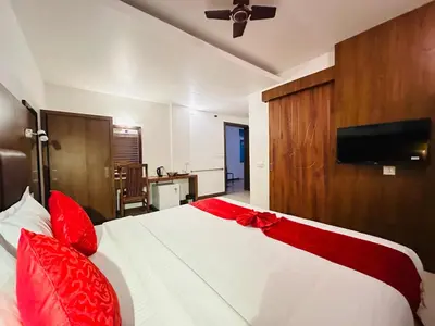 a bedroom with a white bed with red pillows at City Palace Residency Nilambur in Wandūr