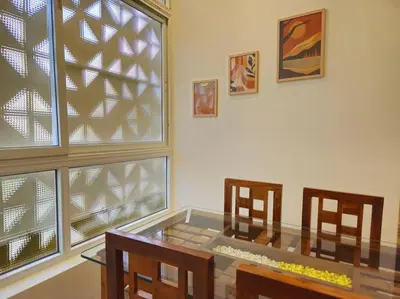 a dining room with a glass table and two chairs at Bricknest hillview in Mysore