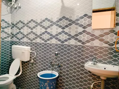 a bathroom with a toilet and a sink at Harvest Hill View Cottage in Ooty