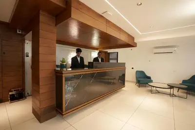 two men standing at a reception desk in a lobby at Stayon Hotels in Palakkad