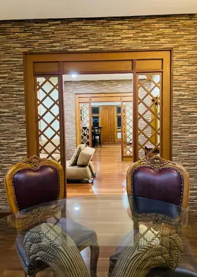 a living room with two chairs and a glass table at Yemcee Rivera in Tellicherry