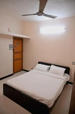 a large bed in a room with a ceiling fan at K K Gardens in Palakkad