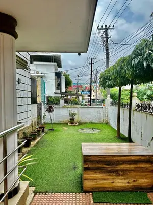 a backyard with a green yard with a bench at K K Gardens in Palakkad