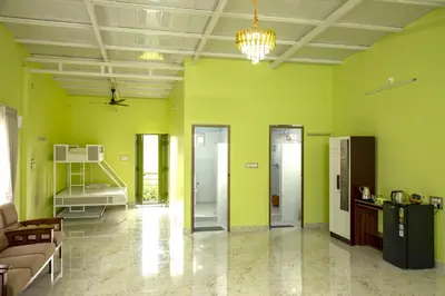 a room with green walls and a couch and a bed at Encanto Farmstay Resort in Mysore