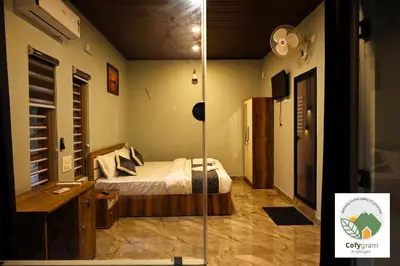a bedroom with a bed and a desk and a mirror at Cofygram cottages in Wayanad