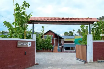 a red brick building with a gate in front of it at Cozy Haven Homestay in Meenangadi