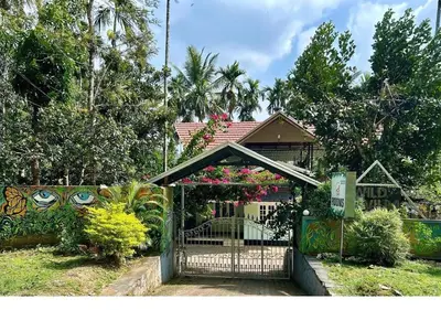 a gate in front of a house with flowers at Wild Villa Homestay in Sultan Bathery
