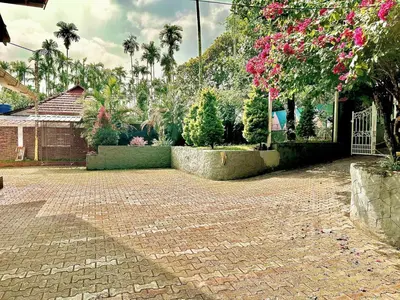 a brick driveway in a yard with trees and flowers at Wild Villa Homestay in Sultan Bathery