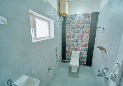 a bathroom with a toilet and a sink and a window at Cucuu Nest Villa Coonoor by VOYE HOMES - Surrounded by Tea Plantations in Coonoor
