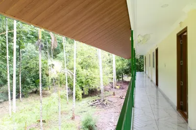 a view from the hallway of a house with a large window at Nutmeg Farmstay with Pool, Vadakkencherry, Palakkad in Vadakkāncheri