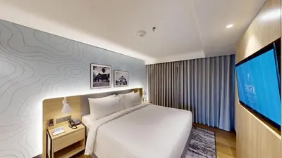 a hotel room with a bed and a flat screen tv at Park Inn & Suites by Radisson Thrissur East Fort in Trichūr