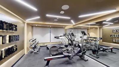 a gym with treadmills and elliptical machines at Park Inn & Suites by Radisson Thrissur East Fort in Trichūr